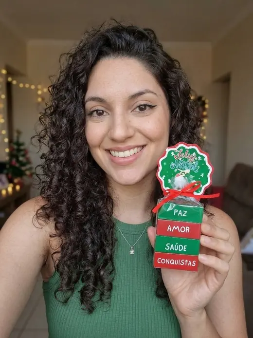 Mulher sorrindo segurando uma lembrancinha de Natal com quatro chocolates Bis